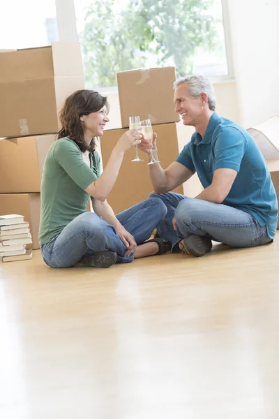 Casal comemorando com champanhe na nova casa — Fotografia de Stock