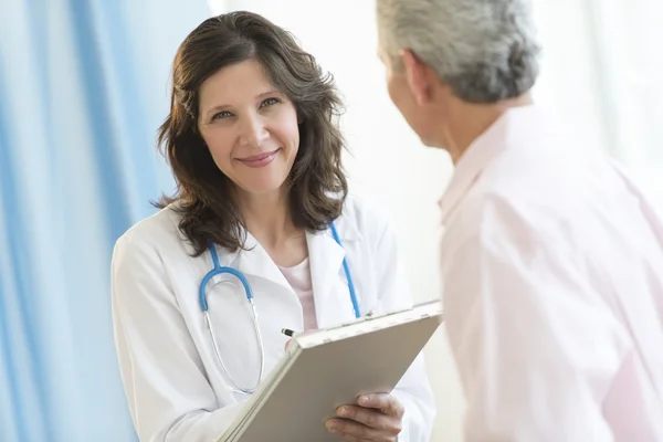 Magnifique médecin debout avec patient en clinique — Photo