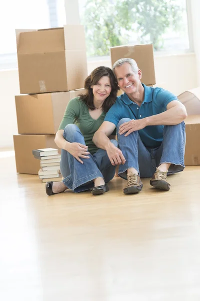 Ältere Paare sitzen zusammen auf dem Fußboden in neuem Haus — Stockfoto