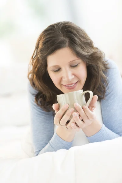 Frau trinkt Kaffee beim Entspannen im Bett — Stockfoto