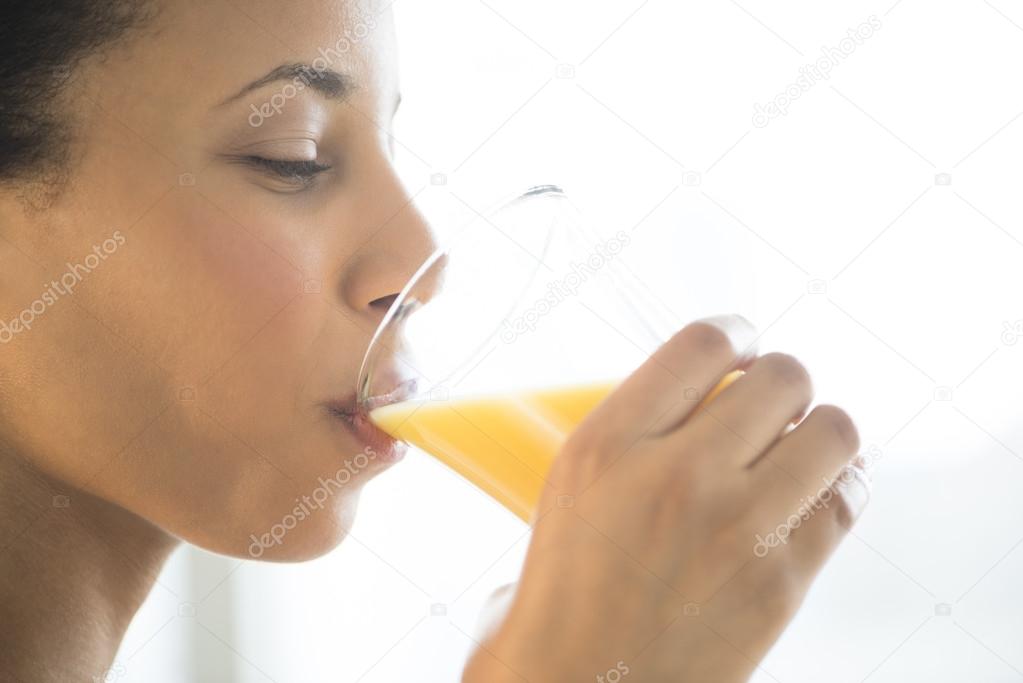Close-Up Of Woman Drinking Orange Juice