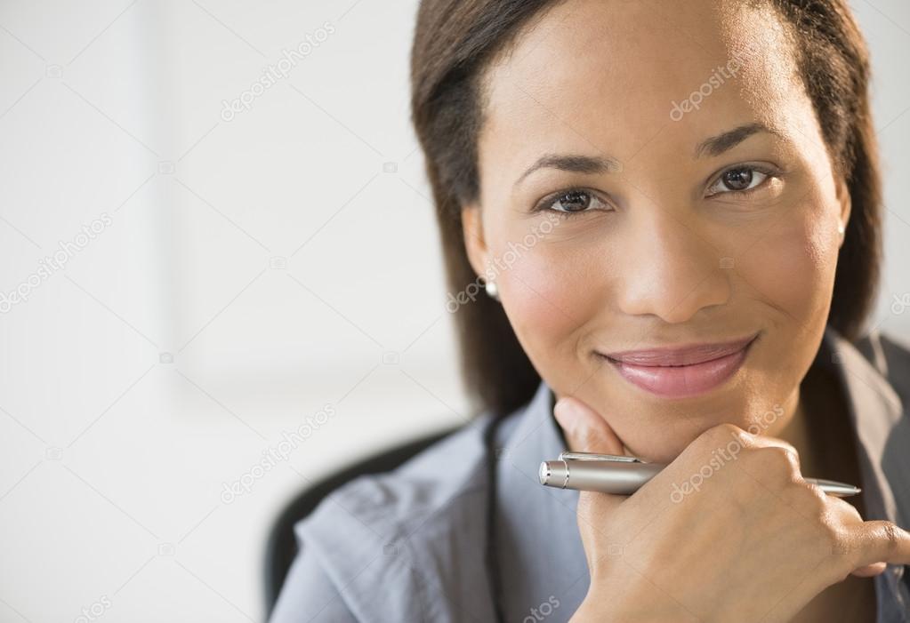 Confident Businesswoman Smiling With Hand On Chin
