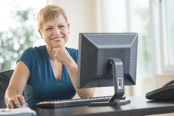 Glad affärskvinna sitter vid dator skrivbord — Stockfoto