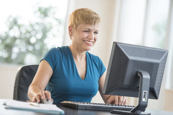 Zufriedene Geschäftsfrau nutzt Computer am Schreibtisch — Stockfoto