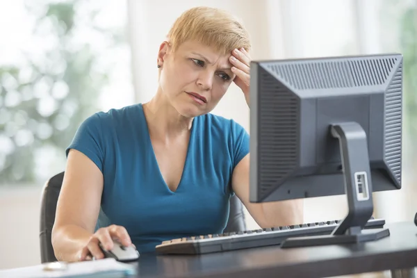 Empresária tensa usando computador na mesa — Fotografia de Stock