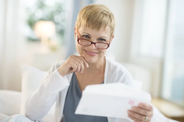 Sorridente donna matura che tiene in mano la busta — Foto Stock