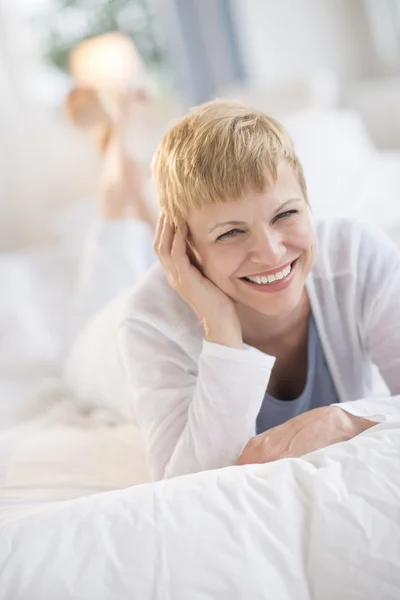 Gelukkig volwassen vrouw liggend in bed — Stockfoto