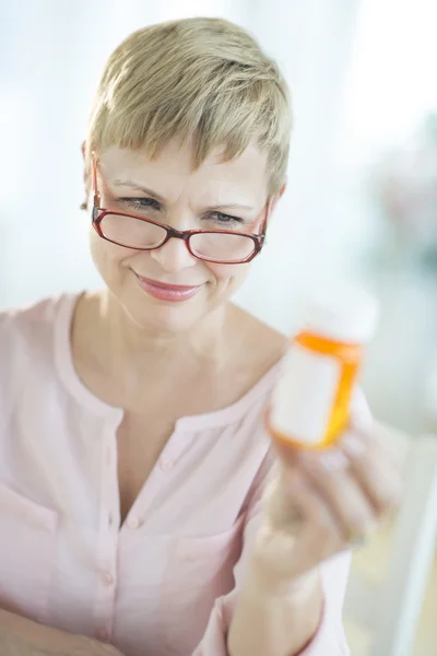 Woman Reading Instructions On Pill Bottle — Stock Photo, Image