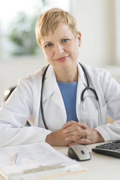 Confident Female Doctor Sitting At Desk — Stock Photo, Image
