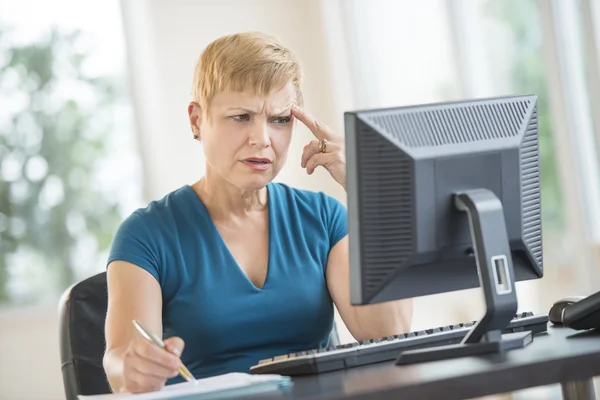 Pengusaha wanita tegang yang bekerja pada PC Desktop — Stok Foto