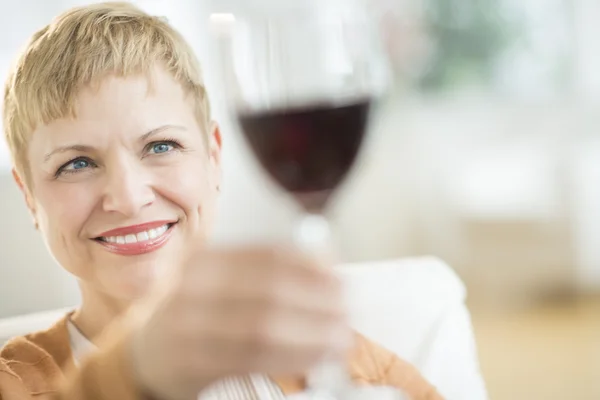 Vrouw bedrijf in rode wijnglas — Stockfoto