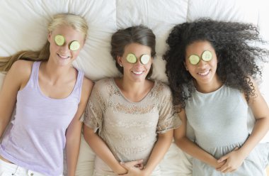Happy Teenage Girls With Cucumber Slices On Their Eyes clipart
