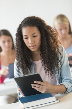 Teenage Student Using Digital Tablet At Desk clipart