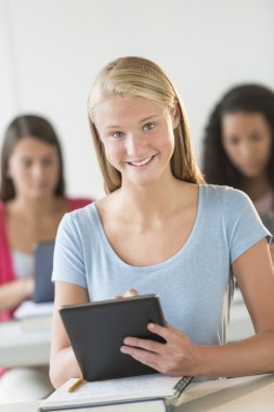 Dijital tablet masa başında tutan güzel genç öğrenci