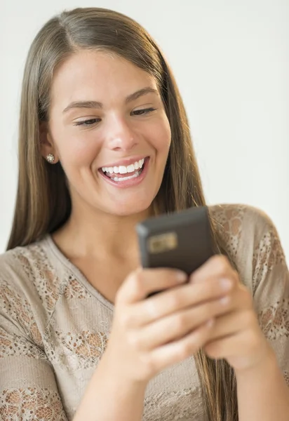 Feliz chica leyendo el mensaje de texto en el teléfono inteligente —  Fotos de Stock