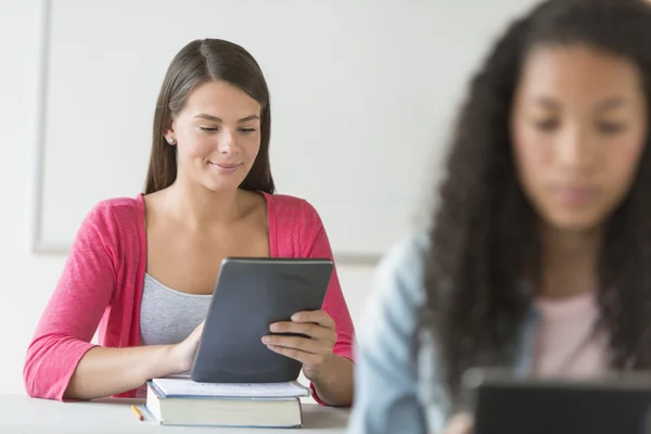 Mooie student met behulp van digitale Tablet PC aan balie — Stockfoto