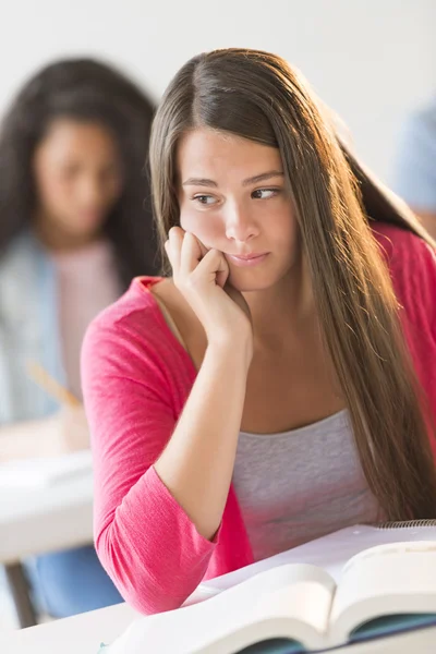 Verveeld tienermeisje zitten in klas — Stockfoto