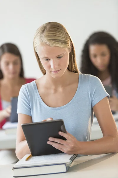 Mooie student met behulp van digitale Tablet PC aan balie — Stockfoto