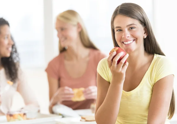 Teenage studente mangiare mela in università mensa — Foto Stock