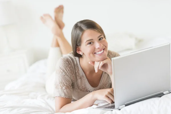 Teenage Girl With Laptop Lying In Bed At Home — Stock Photo, Image