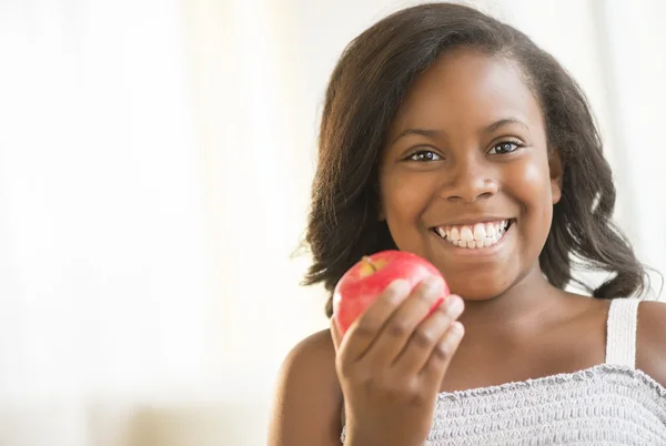 Mädchen hält roten Apfel zu Hause — Stockfoto