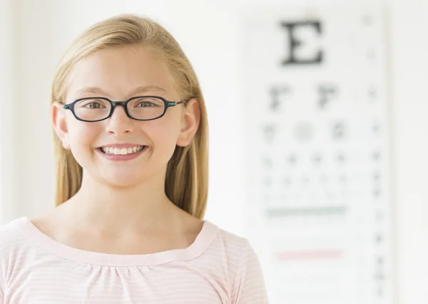 Chica usando gafas contra carta de ojos — Foto de Stock