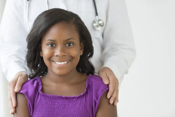 Menina com médico masculino no fundo na clínica — Fotografia de Stock