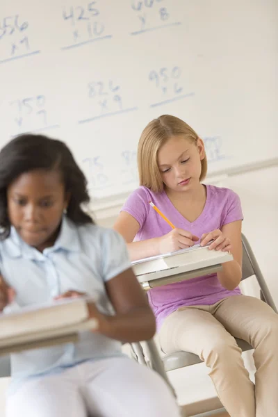 Schoolmeisjes studeren aan Bureau — Stockfoto