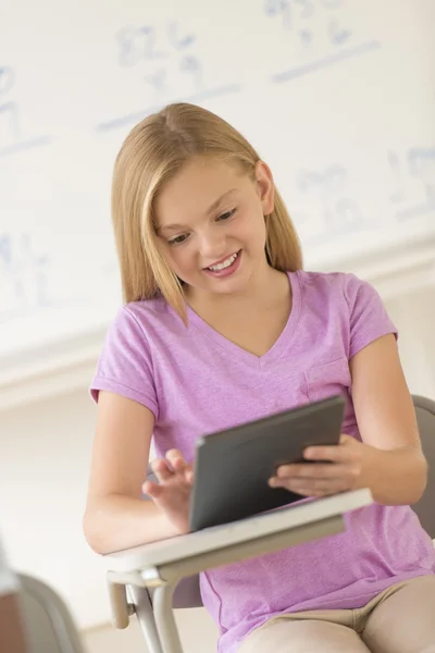 Écolière utilisant la tablette numérique au bureau — Photo