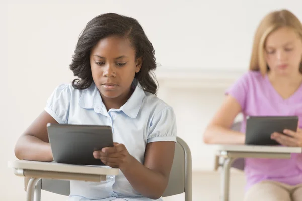Schülerinnen nutzen digitales Tablet am Schultisch — Stockfoto