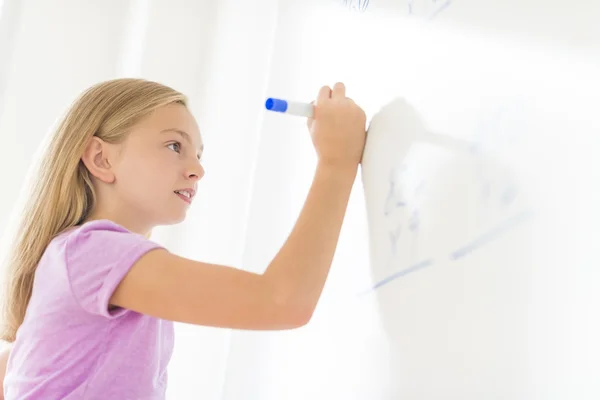 Colegiala resolviendo el problema de matemáticas en la pizarra blanca en el aula — Foto de Stock