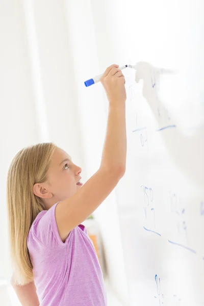 Menina calculando problema matemático no quadro branco na sala de aula — Fotografia de Stock