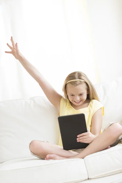 Chica usando tableta digital en el sofá en casa Fotos de stock