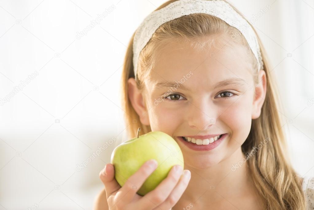 Girl Holding Green Apple At Home