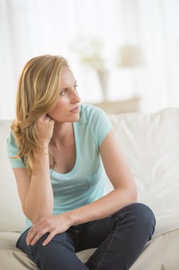 Kanepede oturan düşünceli kadın.