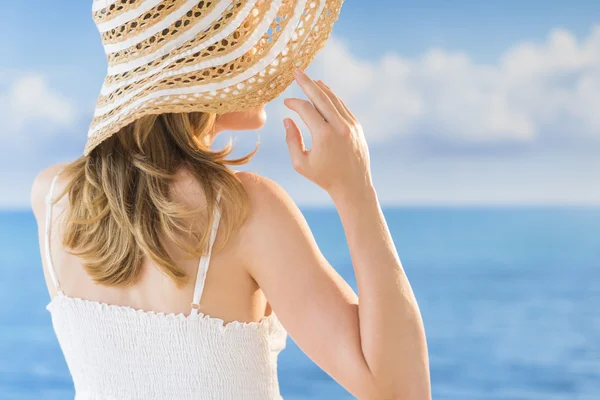 Visão traseira da mulher usando chapéu de sol contra o mar — Fotografia de Stock