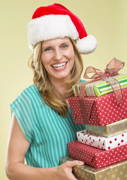 Vrouw met stapel van Kerstmis presenteert — Stockfoto