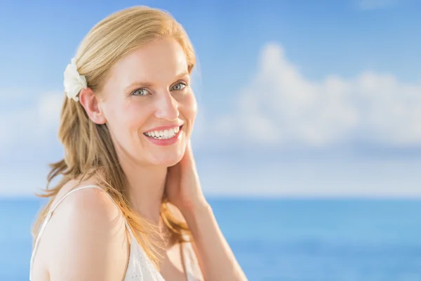 Mujer sonriendo contra el mar en la playa —  Fotos de Stock