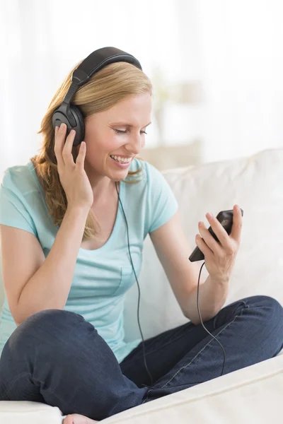 Güzel bir kadın kulaklık aracılığıyla müzik dinlemek — Stok fotoğraf