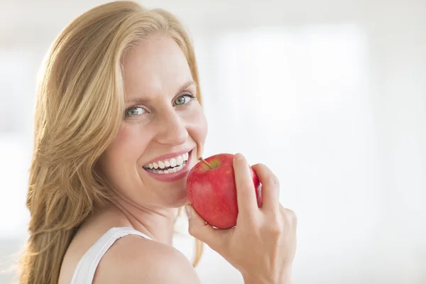 Primer plano de la mujer sosteniendo una manzana en casa — Foto de Stock