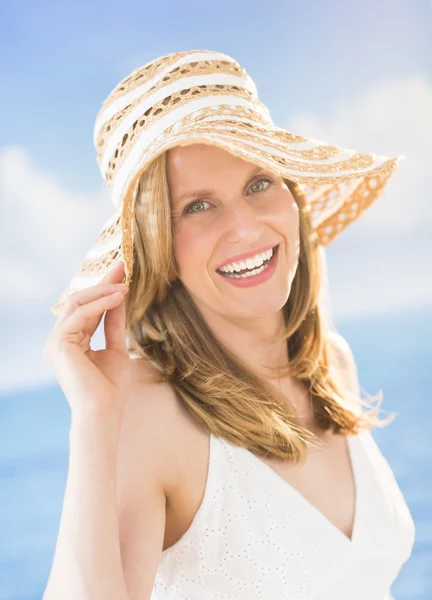 Atractiva mujer con sombrero de sol en la playa —  Fotos de Stock