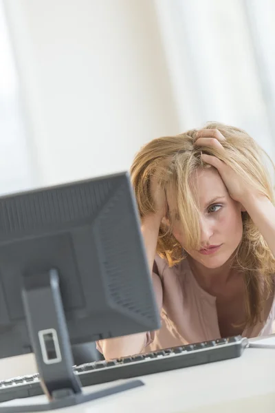 Frustrierte Geschäftsfrau schaut im Büro auf Computer — Stockfoto