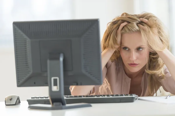 Frustrierte Geschäftsfrau schaut im Büro auf Desktop-PC — Stockfoto