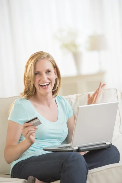 Femme excitée Shopping en ligne à la maison Images De Stock Libres De Droits