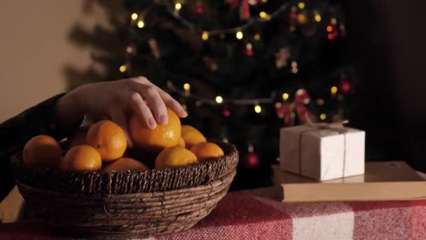 La mano toma mandarinas de un tazón — Vídeo de stock