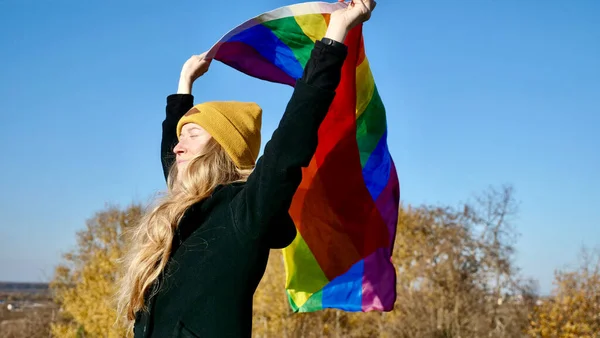 Лесбиянка с прыщами, держащая флаг ЛГБТ — стоковое фото