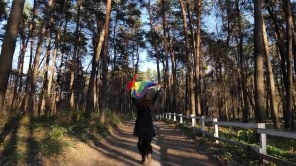 Osoba s vlajkou LGBT v lese — Stock video