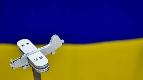 Aereo in legno sullo sfondo della bandiera ucraina — Foto Stock