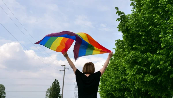 晴れた日には雲と空の背景に虹の平和やLgbtの性別アイデンティティフラグを手にバイセクシャル レズビアン トランスジェンダー 同性愛者を保持し 誇り月にゲイパレードを祝う — ストック写真