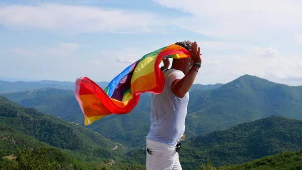 Biseksüel, gay, yaşlı adam, erkek, LGBTQIA bayrağıyla transseksüel yürüyüş, gökkuşağı barışı bir günde doğada yükseliyor ve biseksüellik gününü ya da ulusal çıkış gününü kutluyor.